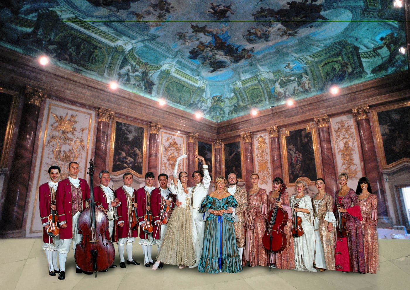 Gruppo di musicisti e ballerini in abiti d’epoca in una sala barocca con affreschi spettacolari sul soffitto.