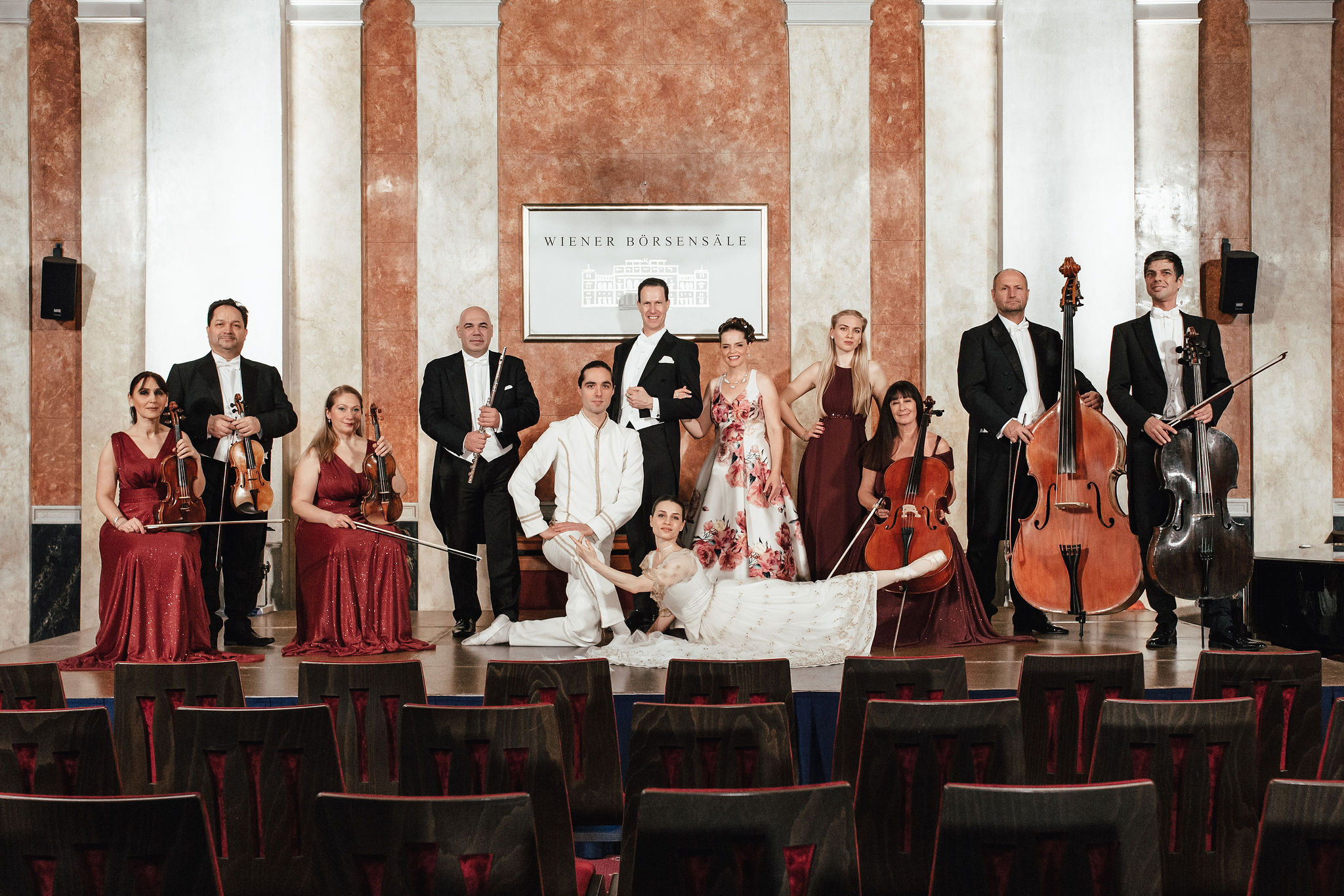 Foto di gruppo sul palco con l’intero ensemble del Wiener Residenz Orchester e i ballerini in abiti da spettacolo nella sala concerti della Börsensäle.