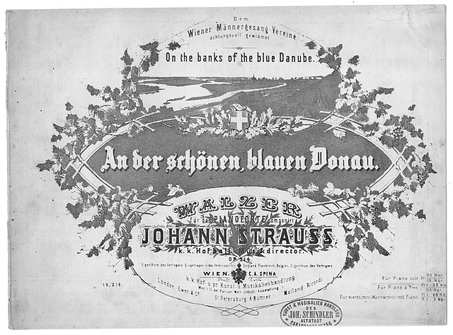 640px-Donauwalzer_Spina_01 Das schwarz-weiße Titelblatt der historischen Notenausgabe des Walzers „An der schönen blauen Donau“ von Johann Strauss. Der Titel steht in einer verzierten Kartusche, umrahmt von Weinreben, mit einer Landschaftszeichnung der Donau darüber.